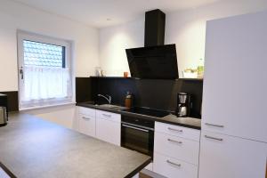 a kitchen with white cabinets and a black sink at Guesthouse-Coburg 1 in Großheirath