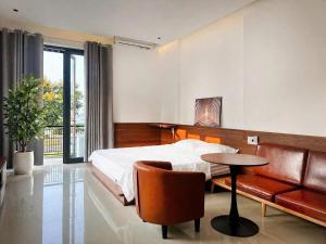 a bedroom with a bed and a table and a chair at NOAM Stay - Sea Corner in Danang