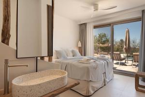 a bedroom with a bed and a table and a window at Sunny Villa-Earthen Stone Gem by etouri in Margarítai