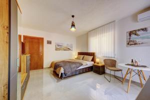 a bedroom with a bed and a table and a desk at Ferienwohnung Nike's in Dobra Voda