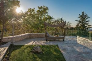 a chair sitting on a patio in a yard at Sunny Villa-Earthen Stone Gem by etouri in Margarítai