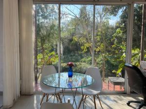 a glass table with chairs and a vase of flowers on it at Mae Wad House in Ban Oi