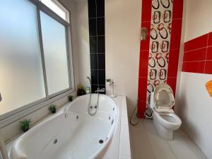 a bathroom with a white tub and a toilet at Mae Wad House in Ban Oi +4 photos