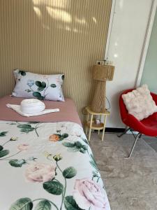 a bedroom with a bed and a red chair at Mae Wad House in Ban Oi