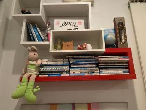 a shelf with books and a stuffed animal on it at Mae Wad House in Ban Oi