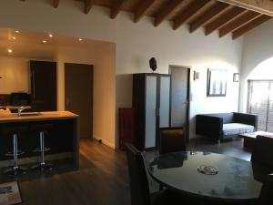 a kitchen and a living room with a table and a couch at CotiLoft - Appartement de standing Climatisé au cœur de La Cotinière in La Cotinière