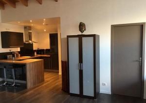 a kitchen with a refrigerator in the middle of a room at CotiLoft - Appartement de standing Climatisé au cœur de La Cotinière in La Cotinière