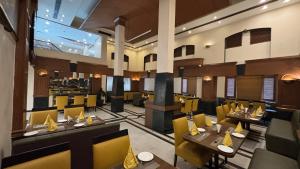 a restaurant with tables and chairs and a large screen at Hotel Residency in Jalandhar +13 photos