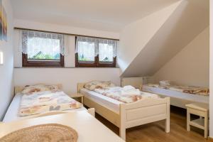 two beds in a room with two windows at Bed & Breakfast Hisa Resje in Bohinj +153 photos