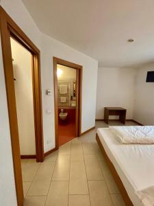 a bedroom with a bed and a bathroom at Suite Maria Residence in Buttrio