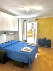 a bedroom with a blue bed with towels on it at Monaco Home just 200 mt from Casinò Monte Carlo in Monte Carlo