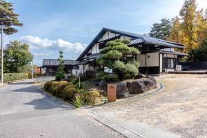 a house with a tree in front of it at Anto Azumino in Azumino