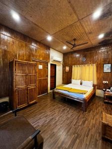 a large room with a bed and wooden walls at Ashaya Agro Farms in Umberpāda