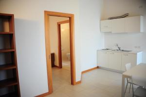 a kitchen with a door open to a kitchen with a sink at Suite Maria Residence in Buttrio
