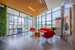 an office with red chairs and a table and windows at ABC Plus Hotel & Homes in Cebu City