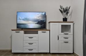 a tv sitting on top of a white dresser at Ferienhaus Grüne Oase in Bar
