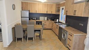 a kitchen with a table and a refrigerator and a sink at Ferienhaus Grüne Oase in Bar