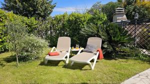 two chairs and a table in the grass at Ferienhaus Grüne Oase in Bar +4 photos