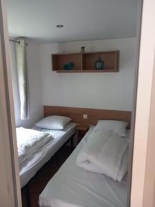 two beds in a room with white sheets and pillows at L'échapée verte in Litteau