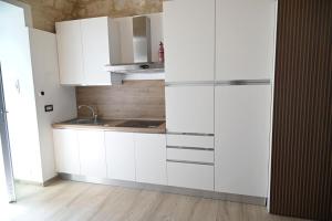 a kitchen with white cabinets and a sink at DreamHouse in Bari +2 photos