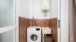 a small bathroom with a washing machine and a toilet at Casa Playa Torrecilla by South Costa in Nerja +20 photos