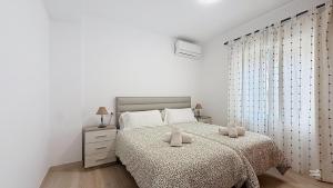 a bedroom with a bed with two stuffed animals on it at Casa Playa Torrecilla by South Costa in Nerja