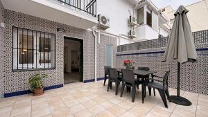 a dining room with a table and an umbrella at Casa Playa Torrecilla by South Costa in Nerja