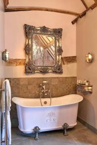 a bath tub in a bathroom with a mirror at Broad Leys in Aylesbury