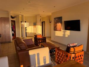 a living room with a couch and a tv at 25 Sunset View in Langstrand