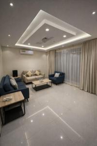 a large living room with blue couches and a table at شاليهات حديقة الوسام لبيوت العطلات 1 in Taif