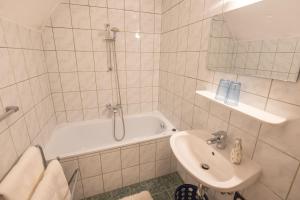 a white bathroom with a tub and a sink at Ferienwohnung Ottmanach Schlosshof in Pischeldorf +19 photos