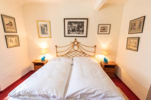 a bedroom with a large white bed with two night stands at Ferienwohnung Ottmanach Schlosshof in Pischeldorf