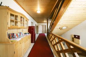 a hallway with a staircase with a red carpet at Pension Seehof in Holzöster