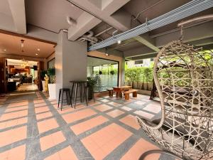 a lobby of a building with a rattan chair at Westkey Kamala Hotel in Kamala Beach