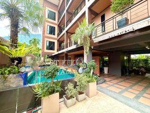 a building with a pool and plants in a courtyard at Westkey Kamala Hotel in Kamala Beach