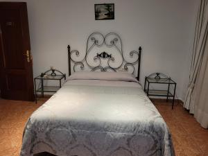 a bed in a bedroom with two end tables at Hostal La Perla in Zalamea de la Serena