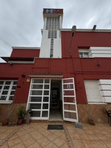a red and white building with a tall tower at Hostal La Perla in Zalamea de la Serena
