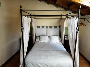 a bedroom with a canopy bed with white sheets and pillows at Hotel Rural Cayetana in Piedrahita