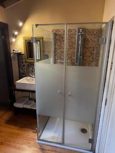 a glass shower in a bathroom with a sink at Hotel Rural Cayetana in Piedrahita +16 photos