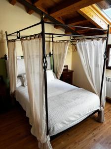 a bedroom with two beds with curtains on them at Hotel Rural Cayetana in Piedrahita