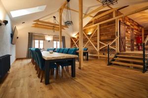 een eetkamer met een tafel en stoelen en houten vloeren bij MX Pokoje in Lipno