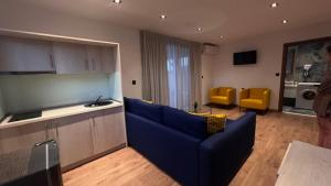 a living room with a blue couch and yellow chairs at THALASSA BOUTIQUE HOTEL in Sarti