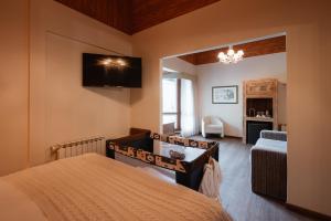 a bedroom with a bed and a tv on the wall at Petit Casa da Montanha in Gramado