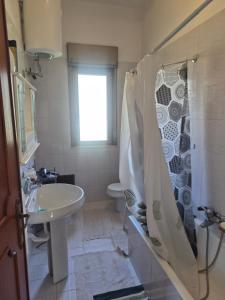 a bathroom with a sink and a shower curtain at Villa Giù, indipendent villa near airport and sea in Cinisi