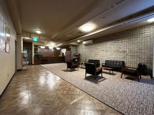 a lobby with couches and chairs in a building at Mizusawa Green Hotel in Oshu
