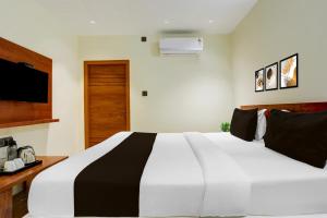 a white and black bed in a room at Super Hotel O Ananthpur Formerly TR Residency in Anantapur