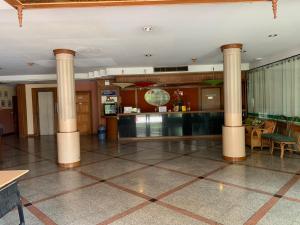 eine Lobby mit Säulen und einer Bar in einem Gebäude in der Unterkunft โรงแรมพิณ in Lampang
