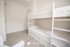 a white bedroom with a bunk bed and a ladder at Garda Nest in Padenghe sul Garda
