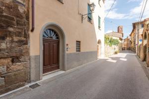 an alley with a brown door on a building at Casa Loretta Vicopisano in Vicopisano