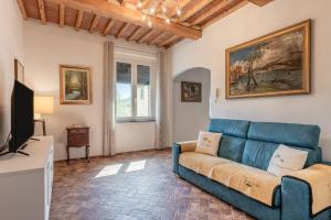 a living room with a blue couch and a tv at Casa Loretta Vicopisano in Vicopisano